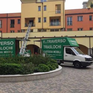 Autoscala e due camion di Fratelli Traverso Traslochi, al lavoro durante un trasloco.